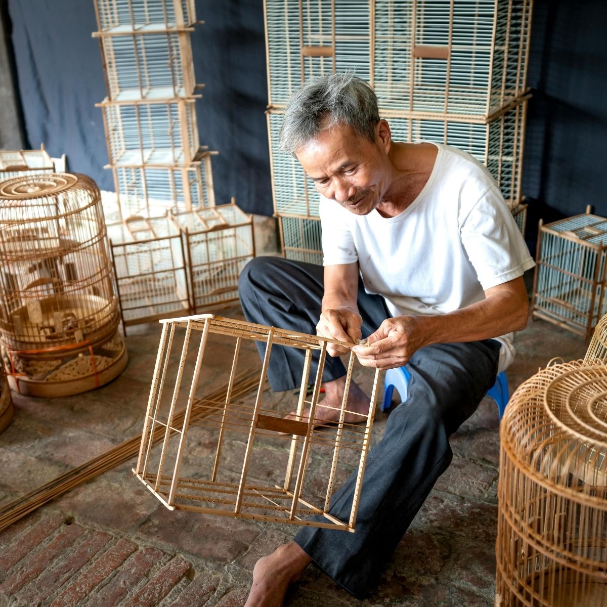 Artisan fabriquant la structure d’un meuble en rotin naturel dans un atelier traditionnel