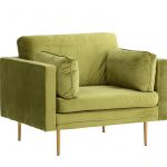 Fauteuil de salon vert Bosco en velours avec coussins et pieds fins dans un intérieur contemporain