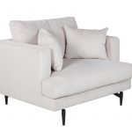 Fauteuil de salon beige Soren en velours côtelé avec assise profonde et pieds acier noir dans un intérieur contemporain