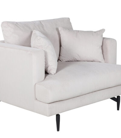 Fauteuil de salon beige Soren en velours côtelé avec assise profonde et pieds acier noir dans un intérieur contemporain