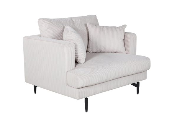 Fauteuil de salon beige Soren en velours côtelé avec assise profonde et pieds acier noir dans un intérieur contemporain