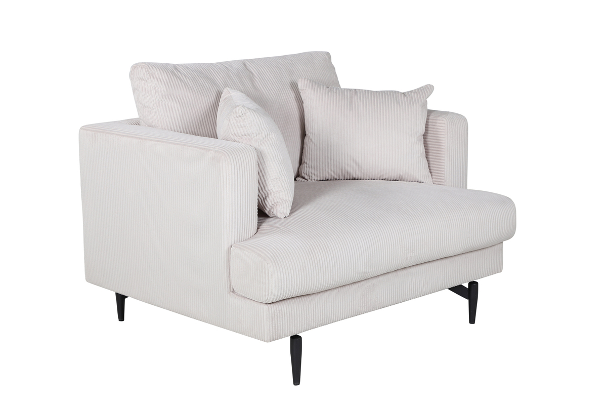Fauteuil de salon beige Soren en velours côtelé avec assise profonde et pieds acier noir dans un intérieur contemporain
