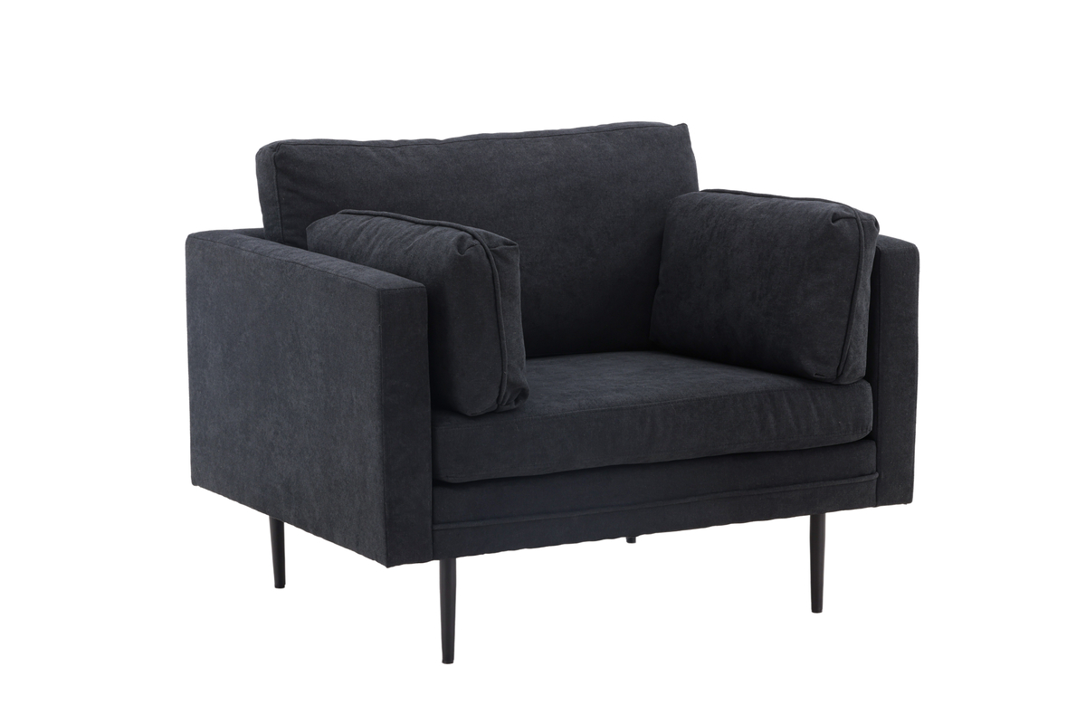 Fauteuil de salon noir Bosco en tissu avec coussins généreux et pieds fins en acier dans un intérieur contemporain