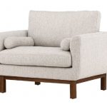 Fauteuil de salon beige Oleg avec structure en bois d’hévéa, assise large et coussins décoratifs